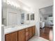 Bathroom featuring a double sink vanity, mirror lighting, and an open view of the connecting primary bedroom at 1256 Camero Dr, Lady Lake, FL 32159