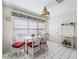 Bright breakfast nook with white wicker chairs and red cushions at 1256 Camero Dr, The Villages, FL 32159