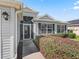 Inviting front entrance with a screened doorway, lush landscaping, and walkway at 1256 Camero Dr, The Villages, FL 32159