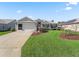 Lovely single-story home with a two-car garage, manicured lawn, and decorative bench at 1256 Camero Dr, Lady Lake, FL 32159