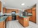 Well-lit kitchen featuring wood cabinets, an island, and modern appliances, ideal for cooking and entertaining at 1256 Camero Dr, Lady Lake, FL 32159