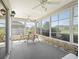 A sunroom with a beautiful stone accent wall with seating and ceiling fans creates a perfect place to relax at 1256 Camero Dr, Lady Lake, FL 32159