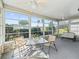 Relaxing sunroom with large windows offering views of lush greenery and outdoor seating at 1256 Camero Dr, Lady Lake, FL 32159