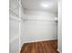 An empty walk-in closet with white walls, shelving and laminated wood flooring at 1256 Camero Dr, Lady Lake, FL 32159