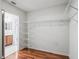 Walk-in closet featuring a view to the bathroom, wood floors, and ample wire shelving at 1256 Camero Dr, Lady Lake, FL 32159