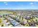 Overhead view of houses in a neighborhood, golf course, and lake, with house marked by a red star at 1357 Owl Dr, The Villages, FL 32163