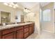 Bathroom featuring double sinks, stone countertops, and an adjoining glass block shower at 1357 Owl Dr, The Villages, FL 32163