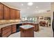 Open concept kitchen with stone countertops, stainless steel sink, and wooden cabinets at 1357 Owl Dr, The Villages, FL 32163