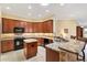 Kitchen featuring stone countertops, dark wood cabinetry, and modern appliances at 1357 Owl Dr, The Villages, FL 32163