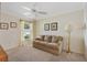 Comfortable living room with neutral tones, a ceiling fan, and natural light from the window at 1357 Owl Dr, The Villages, FL 32163