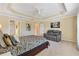 Bright main bedroom featuring a tray ceiling and a seating area at 1357 Owl Dr, The Villages, FL 32163