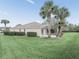 Exterior backyard view shows well-maintained lawn, manicured bushes and screened patio at 164 Palermo Pl, The Villages, FL 32159