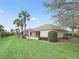 Back of the house shows a well-kept lawn, screened patio and manicured hedges and other greenery at 164 Palermo Pl, The Villages, FL 32159