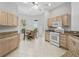 Well-lit kitchen with light-colored cabinets, white appliances, and a cozy breakfast nook area at 164 Palermo Pl, The Villages, FL 32159