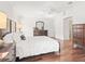 Virtually staged main bedroom featuring hardwood floors, dresser, lamps, and a picturesque view at 164 Palermo Pl, The Villages, FL 32159