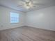 Bright bedroom with light-colored wood floors, ceiling fan, and a large window at 1671 Campos Dr, The Villages, FL 32162