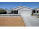 Charming home with white picket fence, attached garage, and well-manicured lawn at 1671 Campos Dr, The Villages, FL 32162