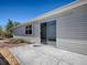 Back patio with concrete pavers, glass sliding door to the interior, and siding on the home at 1671 Campos Dr, The Villages, FL 32162