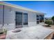 Back patio with concrete pavers, glass sliding door, siding on the home, and landscaping at 1671 Campos Dr, The Villages, FL 32162