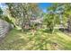 Lush backyard with mature trees and a screened-in lanai, offering privacy and a tranquil outdoor space at 17408 Tailfeather Ct, Clermont, FL 34711