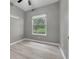 This bedroom features gray walls, a window and wood-look floors at 17408 Tailfeather Ct, Clermont, FL 34711