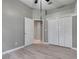 This bedroom has gray walls, ceiling fan, wood-look floors and a closet at 17408 Tailfeather Ct, Clermont, FL 34711