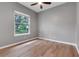 Cozy bedroom with wood-look flooring and a window offering views of the landscaped yard at 17408 Tailfeather Ct, Clermont, FL 34711