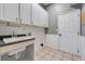 This laundry room features cabinets, a sink and tiled floor at 17408 Tailfeather Ct, Clermont, FL 34711