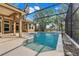 Screen enclosed pool with connected patio and view of the backyard at 17408 Tailfeather Ct, Clermont, FL 34711