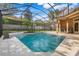 Inviting screened-in pool area with water feature, basketball hoop, and outdoor kitchen for outdoor entertaining at 17408 Tailfeather Ct, Clermont, FL 34711