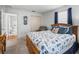 Bright bedroom features a wood frame bed with nautical themed bedding, closet and ensuite bathroom at 17442 Se 79Th Lovewood Ave, The Villages, FL 32162