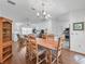 Bright dining area featuring a chandelier, hardwood flooring, and an open layout at 17442 Se 79Th Lovewood Ave, The Villages, FL 32162