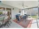 View of screened lanai with ceiling fan, dining table and access to the backyard and inside bar at 17442 Se 79Th Lovewood Ave, The Villages, FL 32162