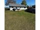 Rear view of a house featuring an outdoor seating area and a spacious lawn at 18316 Keene Rd, Altoona, FL 32702