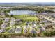 Areal view of houses with lush green landscapes and a beautiful lake surrounded by trees at 1841 Dunn Cove Dr, Apopka, FL 32703