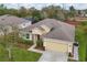 An aerial view of a tan house with a brown roof with green grass and landscaping at 1841 Dunn Cove Dr, Apopka, FL 32703