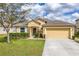 Charming single-story home featuring a manicured lawn, stone accents, and an attached two-car garage at 1841 Dunn Cove Dr, Apopka, FL 32703