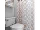 The white toilet offers a clean look, complemented by a patterned shower curtain at 1917 Emily Blvd, Winter Haven, FL 33884