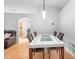 Modern dining room with hardwood floors, white table, and a view into living space at 1917 Emily Blvd, Winter Haven, FL 33884