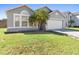 Charming single Gathering home with a well-maintained lawn, a two-car garage, and lush landscaping at 1917 Emily Blvd, Winter Haven, FL 33884