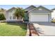 Inviting home featuring a manicured lawn, two-car garage, well kept shrubbery, and decorative walkway at 1917 Emily Blvd, Winter Haven, FL 33884