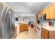 Well-lit kitchen with wood cabinets, stainless steel fridge, and a view into the living room at 1917 Emily Blvd, Winter Haven, FL 33884