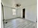 Cozy bedroom with laminate flooring, ceiling fan, and a bright window view at 206 Aspen Cir, Leesburg, FL 34748