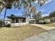 Beautiful single-story home featuring a screened-in porch, a covered carport, and a well-manicured lawn at 206 Aspen Cir, Leesburg, FL 34748