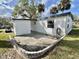 Outdoor patio with partial brick wall and well-manicured lawn at 206 Aspen Cir, Leesburg, FL 34748