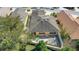 Aerial view of backyard featuring a patio, green lawn, perimeter fence, and mature tree coverage at 2165 Smoaks St, The Villages, FL 32162