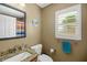 Bright bathroom with granite vanity, shuttered window, tile floors and decorative accents at 2165 Smoaks St, The Villages, FL 32162