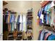 Organized walk-in closet featuring shelves, rods, shoes and clothing at 2165 Smoaks St, The Villages, FL 32162