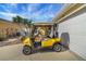 A yellow golf cart sits in front of a well-maintained one story home with an attached two car garage at 2165 Smoaks St, The Villages, FL 32162