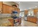 Kitchen features wood cabinets, stainless steel appliances, granite counters and wood floors at 2165 Smoaks St, The Villages, FL 32162